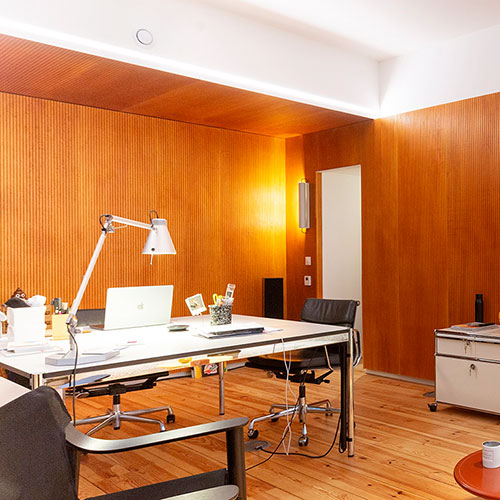 Panneau acoustique en bois rainuré ab pano 50 aux murs d'un ensemble de bureaux