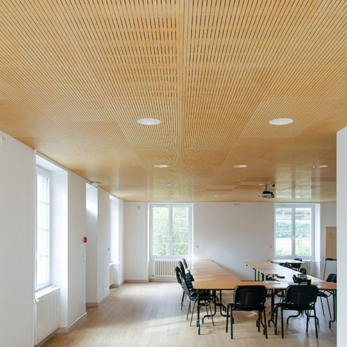 Panneaux acoustiques en bois rainurés ab pano 25 au plafond d'une salle de réunion